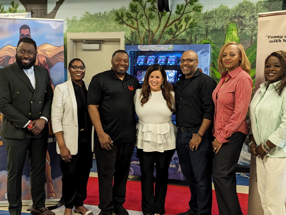 Members of Heal The Hood in front of book vending machine