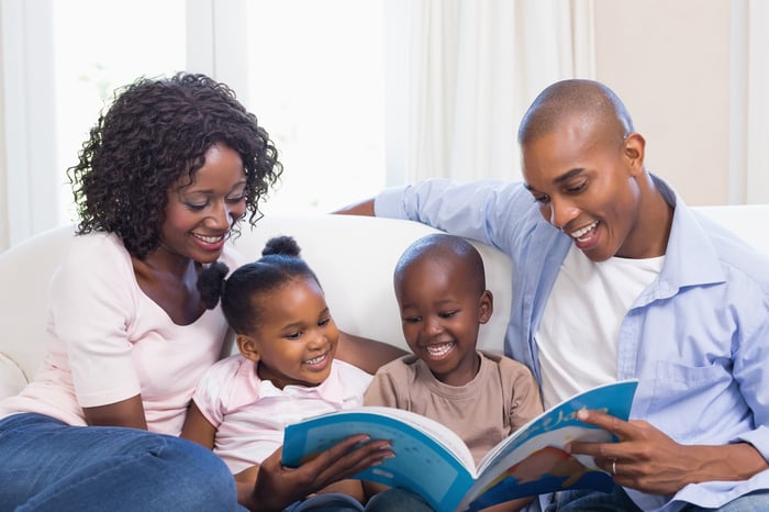 Happy family on the couch reading storybook at home in the living room