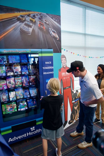 Eric Jones Helps Student Vend a Book From Inchy's Bookworm Vending Machine