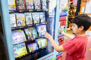 student with book vending machine